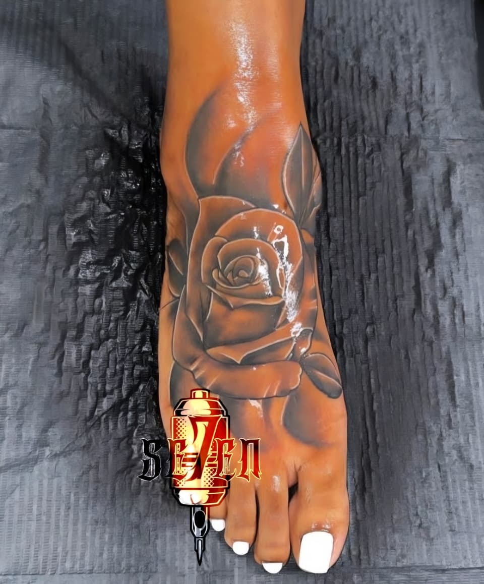 Black and grey rose tattoo covering the top of a foot